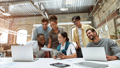 A group of co-workers smiling and looking at company results.