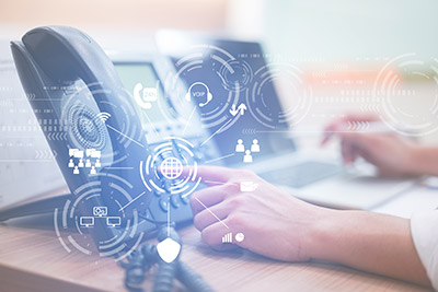 A closeup of a person using a phone with VoIP icons over the image.